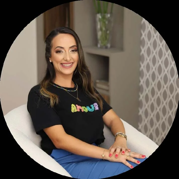 Viviane Waquil sentada em uma poltrona do consultório, sorrindo